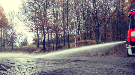 Fire hose in hand to remove the consequences of floods.
