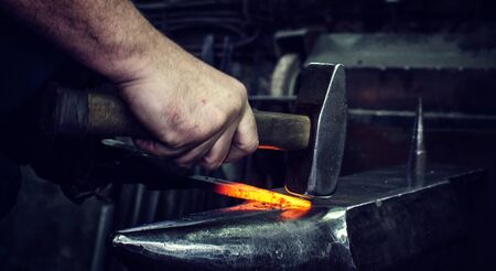 Blacksmith at work, hit with a hammer by a hot metal on the anvil.の写真素材