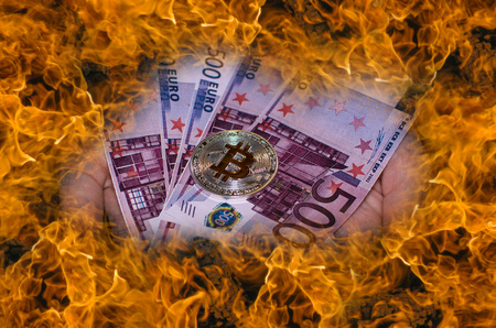  A virtual bitcoin coins versus burning euro banknotes.の写真素材