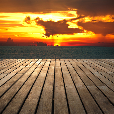 Wooden platform beside tropical sunset seaの写真素材