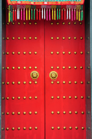 Red chinese door with a lion hand doorの写真素材