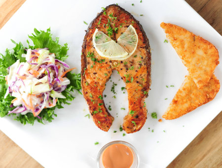 Fried steak from a salmon with a sauce and lemon, ready to the serve の写真素材
