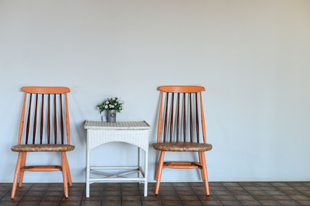 Table with wooden chair near white wall