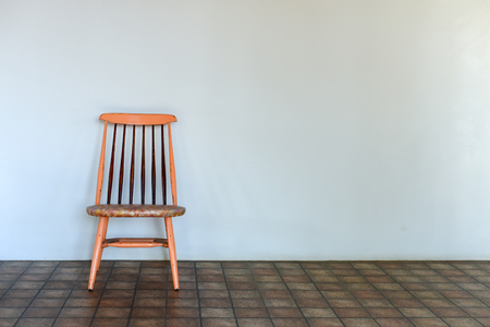 Wooden chair with white wallの写真素材