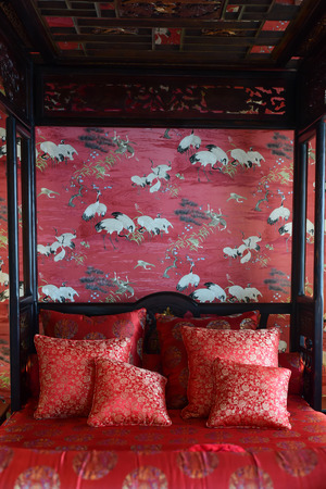 Red decorated bed in Chinese style set for the bride and the groom.の写真素材