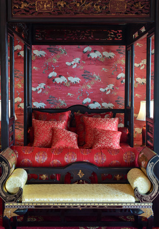 Red decorated bed in Chinese style set for the bride and the groom.の写真素材