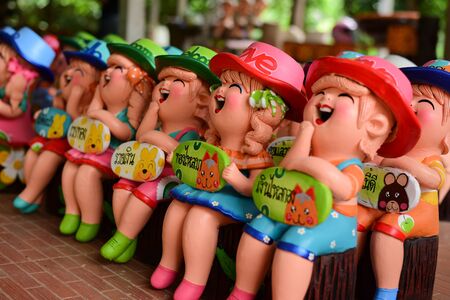 Clay Doll lovely and smiling happily for decorated (Quote Thai language on label mean Happy and Lucky)の写真素材