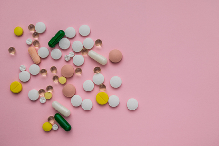 scattered multicolored pills on a pink backgroundの写真素材