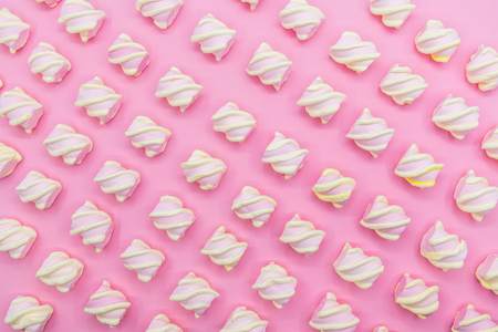 Flat lay top view tasty appetizing concept, minimal Sweet Treat Swirl Candy Lollipop marshmallow Colorful pattern on pink pastel background and copy space.の写真素材