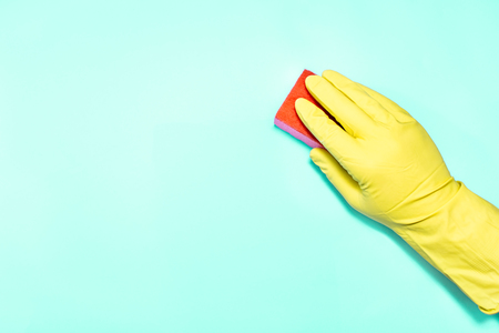 Man hand in glove with sponge on turquoise background.の写真素材
