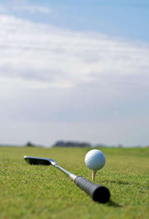 Golf ball in tall green grass set against blue skyの写真素材