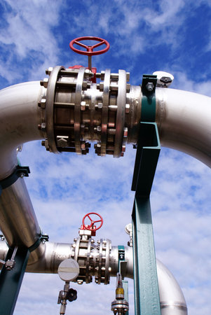 Pipes, bolts, valves against blue sky                 