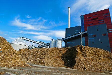 bio power plant with storage of wooden fuel (biomass) against blue skyの写真素材