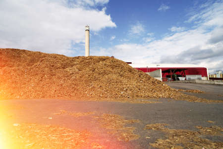 bio power plant with storage of wooden fuel against blue skyの写真素材