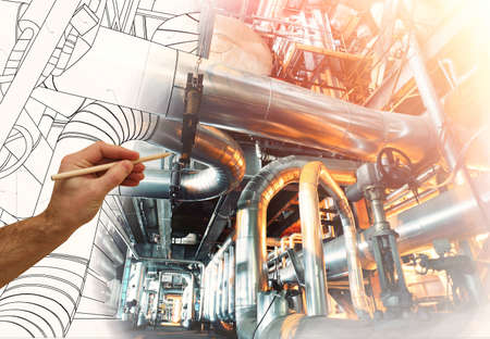 man's hand draws a design of factory combined with photo of modern industrial power plant