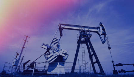 Extraction of oil. Pump jack and oil wellhead. Toned.