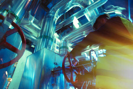 industrial factory worker turning red wheel of valveの写真素材