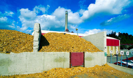 bio power plant with storage of wooden fuel against blue skyの写真素材