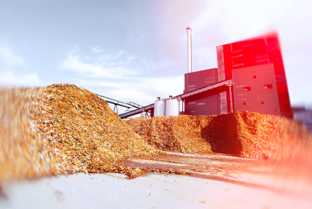 bio power plant with storage of wooden fuel against blue sky. Toned image. Motion blur effect.の写真素材