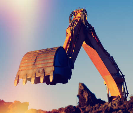 Hydraulic excavator at work. Shovel bucket against blue skyの写真素材