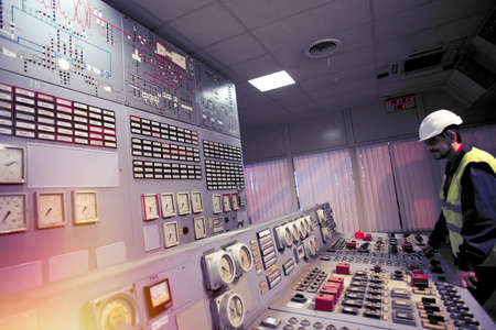 operator holds his hands on the control panel of old power plantのeditorial素材
