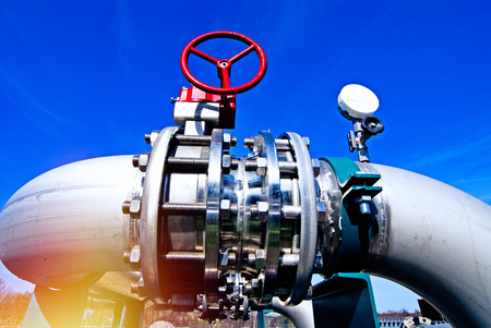 Industrial zone, Steel pipelines and valves against blue sky