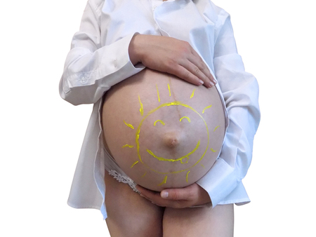beauty of a pregnant woman naked belly of a pregnant woman with a painted sunの写真素材