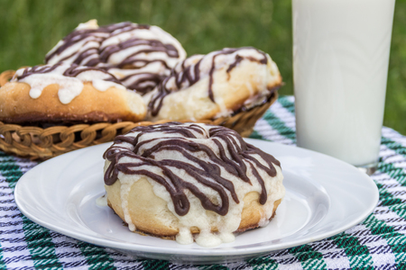 Homemade cinnabon cinnamon buns with cream cheese glaze and chocolate icingの写真素材