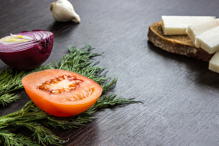 cut red onions, tomato, dill, lard (salo) and garlic on wooden table.の写真素材