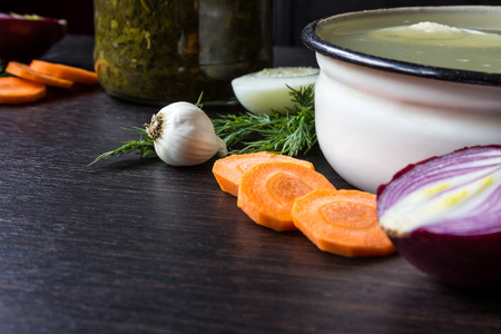 Soup with sorrel, vegetables and boiled egg, red onion, carrots, garlic, dill on dark wooden tableの写真素材