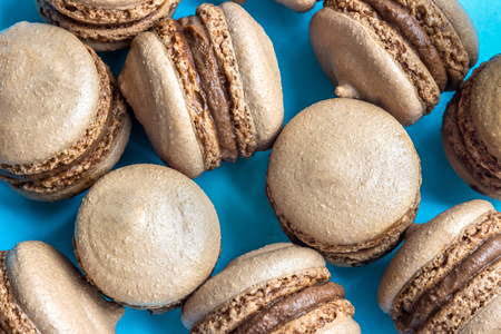Chocolate macaron or macaroon cake on blue background, top viewの写真素材