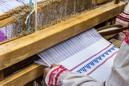 Woman weaving traditional slavic linen on horizontal loomの写真素材