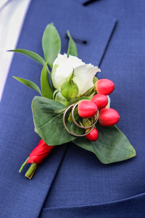 wedding rings on boutonniere on jacket of groomの写真素材