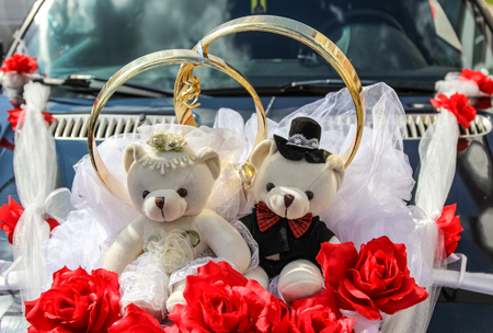Wedding rings and couple of teddy bears on car (decoration)の写真素材