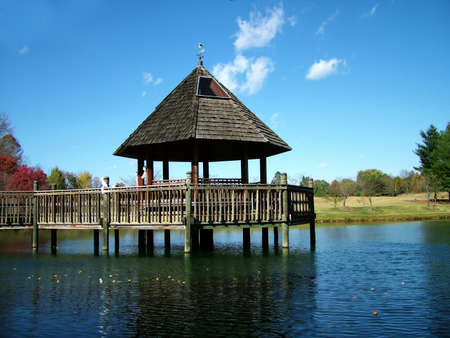 View of a gazebo over water, fall colors and foliageの写真素材