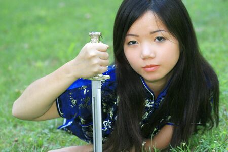 Portrait of a young asian female in traditional Vietnamese dress with  swordの写真素材