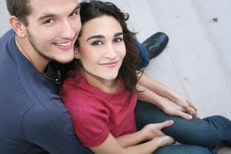 Young couple in love, outdoors - urban /  street setting, posing, hugging, and having fun