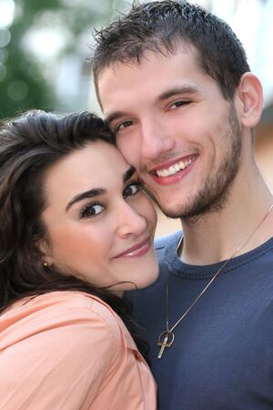 Young couple in love, outdoors - urban /  street setting, posing and having fun