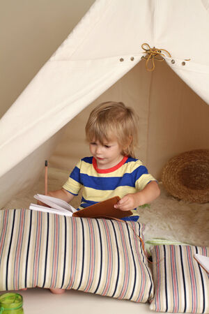 Child playing at home indoors with a teepee tentの写真素材