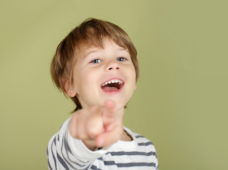 Happy, laughing child pointing straight at viewerの写真素材