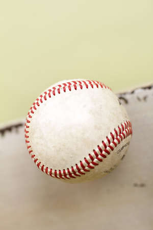 Used, worn out baseball on rustic wood bench, copyspaceの写真素材