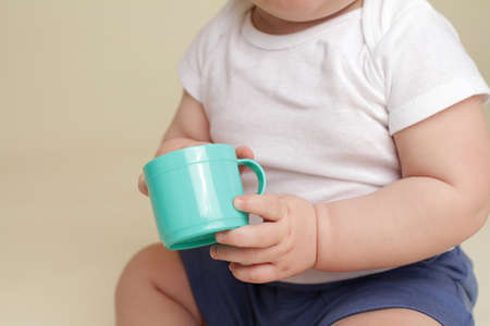 Child holding a cup, eating or drinking, baby nutrition conceptの写真素材