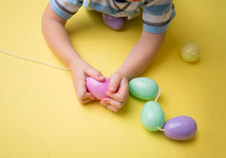 Kids easter activity and crafts: stringing plastic easter eggsの写真素材