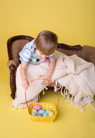 Child playing with an easter egg basket, easte egg hunt concept.の写真素材