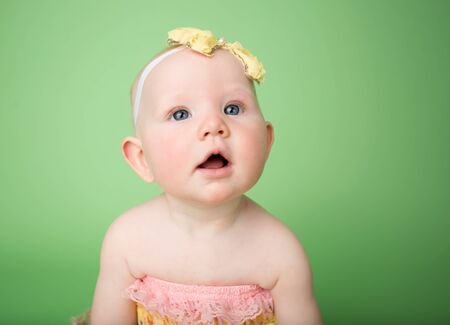 Baby in Easter outfit and headband looking up, infant baby girlの写真素材