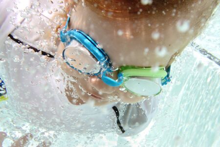 Child diving and swimming in pool underwater, summer or sports themeの写真素材