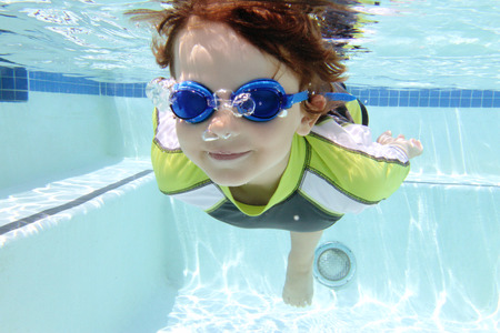 Child diving and swimming in pool underwater, summer or sports themeの写真素材