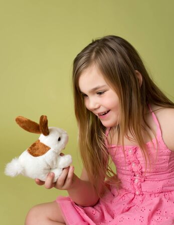Happy smiling child, girl playing with Easter Bunnyの写真素材