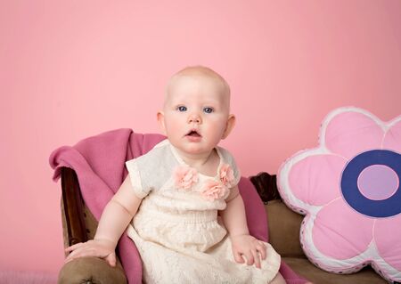 Baby sitting on couch with blanket, baby room and furniture conceptの写真素材
