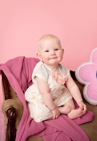 Baby sitting on couch with blanket, baby room and furniture conceptの写真素材